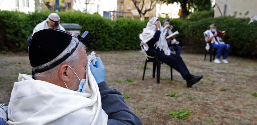 Men pray while keeping distance from each other outside their closed synagogue in Netanya, Israel, on April 23.