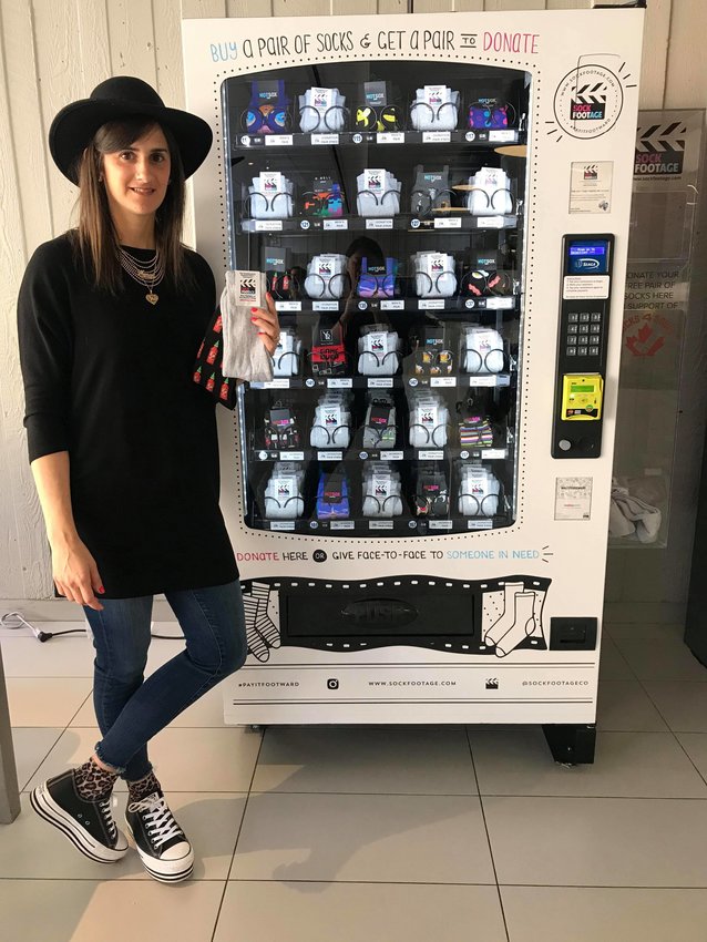 Marisa Sheff alongside one of her sock vending machines at Ryerson University.
