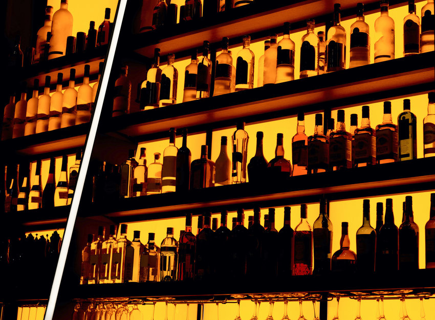 Rows of bottles sitting on shelf in a bar, trademarks deleted, bottle design altered