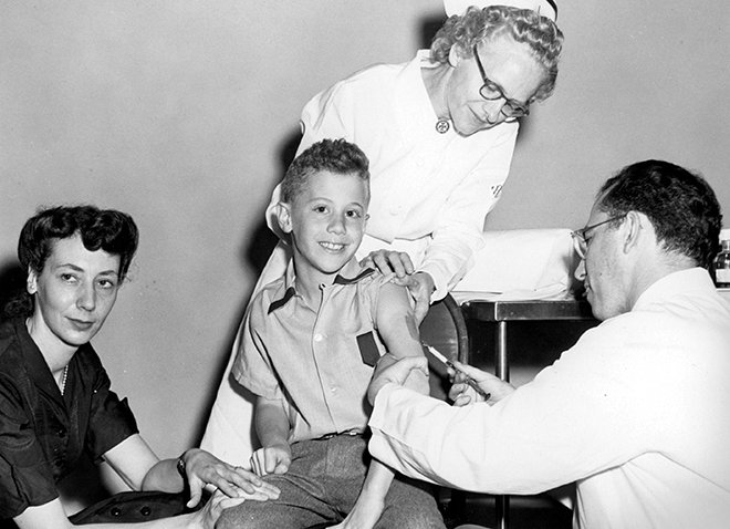 Peter Salk receives a polio vaccination from his father Jonas.