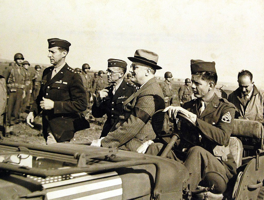 President Franklin D. Roosevelt reviews his troops in Casablanca from a jeep, on Jan. 14, 1943. The tall walking figure at his side is Lieutenant General Mark W. Clark.