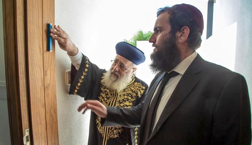 Israel&rsquo;s Chief Sephardic Rabbi Yitzhak Yosef affixes a mezuzah to a doorpost of the newly built Jewish school in the United Arab Emirates while on his first trip to an Arab country, as Chabad Rabbi Levi Duchman of the UAE looks on.