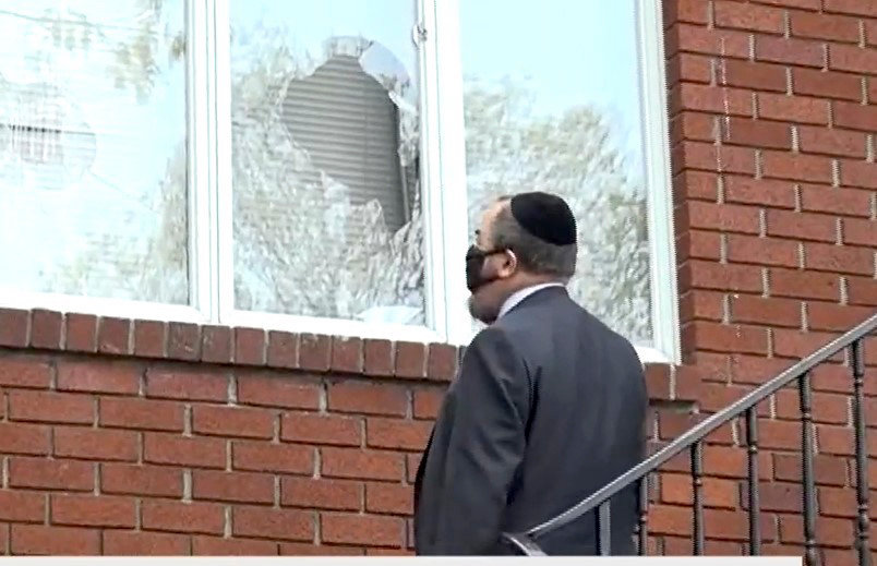 Rabbi inspects damage at Chabad of Riverdale. Vandals broke windows at four Riverdale synagogues.