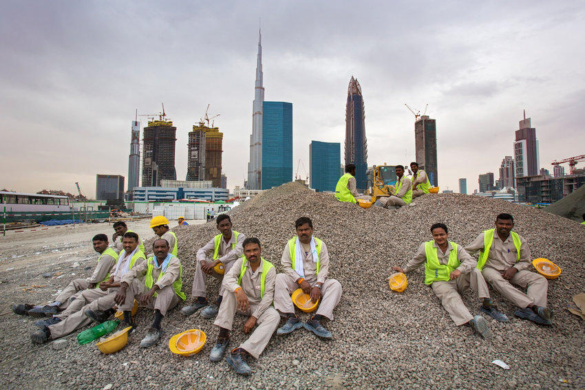 Panorama of Dubai Financial Center and construction site with workers on a break.