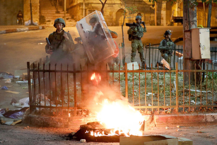 Palestinian youth clash with Israeli security forces in Hebron during a protest over tension in Jerusalem, on April 26.