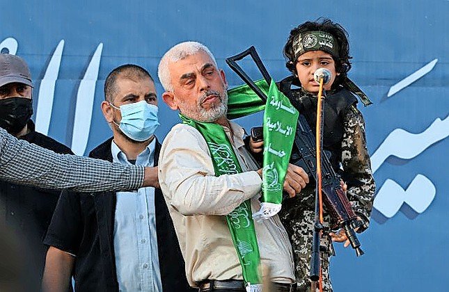 Hamas leader Yahya Sinwar holds a Palestinian child dressed as a Hamas fighter during a rally in Gaza City on May 24.