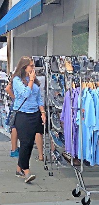 A shopper on Central Avenue considers the merchandise outside a store during the Cedarhurst Sidewalk Sale in 2019.
