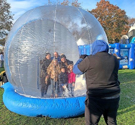Family in a snow globe, at the Kulanu Winter Fest.