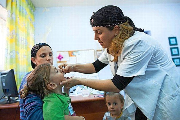 An child is vaccinated at a Children's Medical Center in Neve Yaakov, Jerusalem, in 2013.