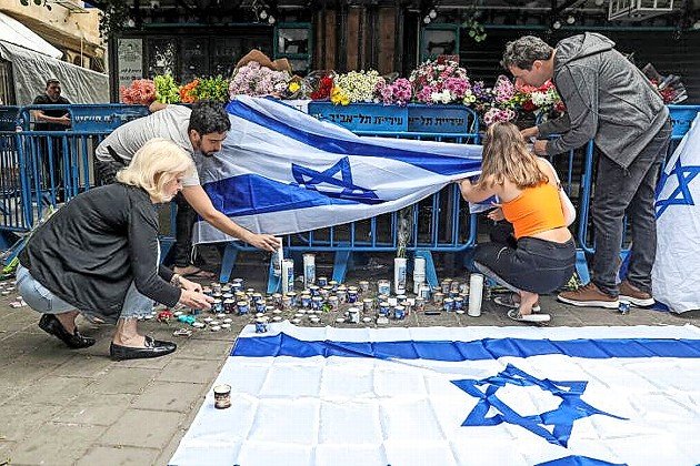 Israelis light memorial candles at the site of the June 7 terrorist attack in Tel Aviv.