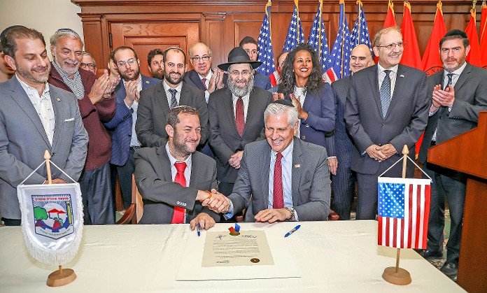 Nassau Legislator Mazi Melesa Pilip of Great Neck &mdash; the only woman in this photo that ran on The Jewish Star&rsquo;s cover last May &mdash; spoke forcefully on Israel&rsquo;s behalf at an event in Mineola where Shomron Regional Council Chair Yossi Dagan and Nassau County Executive Bruce Blakeman shook hands after signing an economic, cultural and friendship agreement. At far left: Five Towns Assemblyman Ari Brown and former Boro Park Assemblyman Dov Hikind; in center, Rabbi Anchelle Perl of Chabad of Mineola; at far right, Rabbi Shalom Axelrod of the Young Israel of Woodmere.