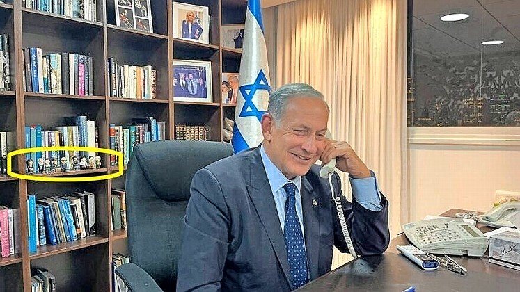 Prime Minister-designate Benjamin Netanyahu at his desk with the figurines (circled).