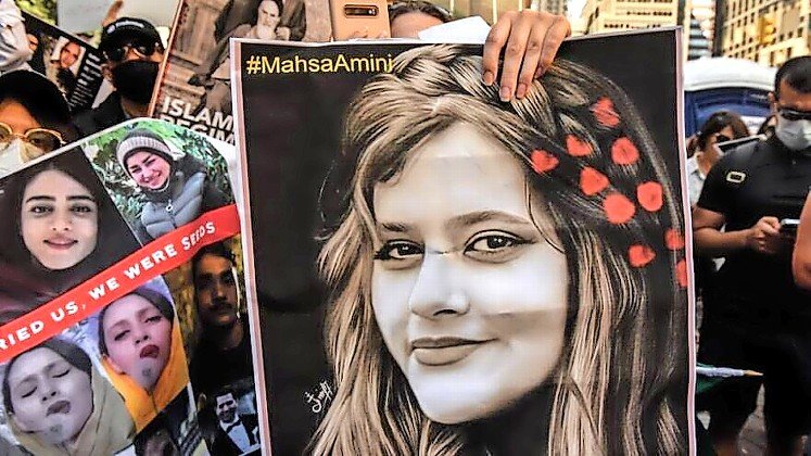 Protester holds a picture of Mahsa Amini, Kurdish woman murdered by Iran&rsquo;s morality police.