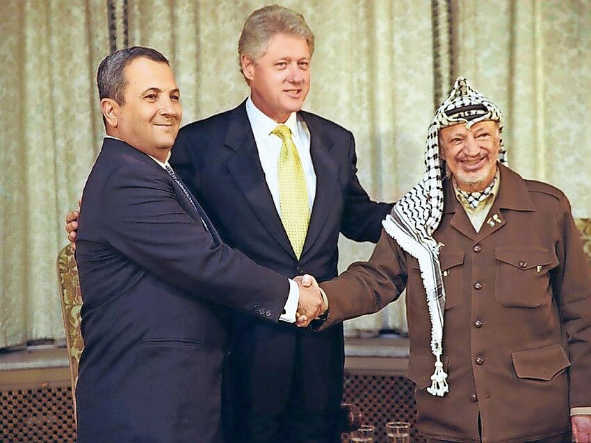 Israeli Prime Minister Ehud Barak and PA Chairman Yasser Arafat shake hands at a trilateral meeting at the US Ambassador&rsquo;s residence in Oslo, Norway, on Nov. 12, 1999.