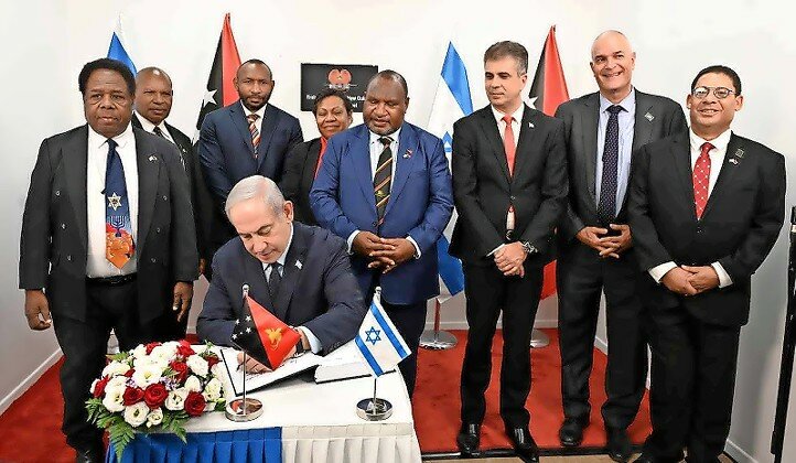Israeli Prime Minister Benjamin Netanyahu signed documents Tuesday as Papua New Guinea Prime Minister James Marape looked on.