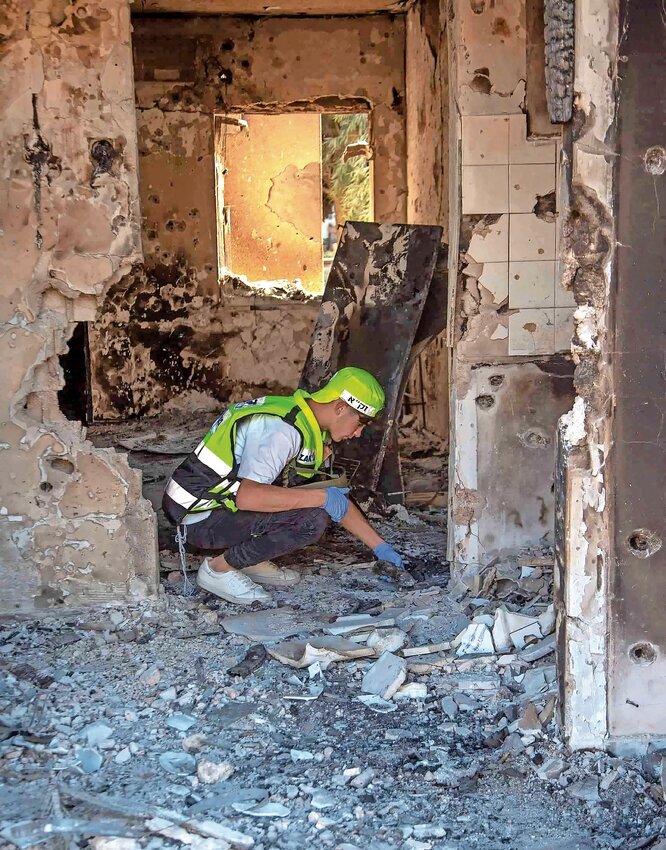 Members of ZAKA amidst the destruction caused by Hamas terrorists in Kfar Aza near the border with Gaza, collecting dead bodies &mdash; and pieces of bodies &mdash;on Oct. 15.