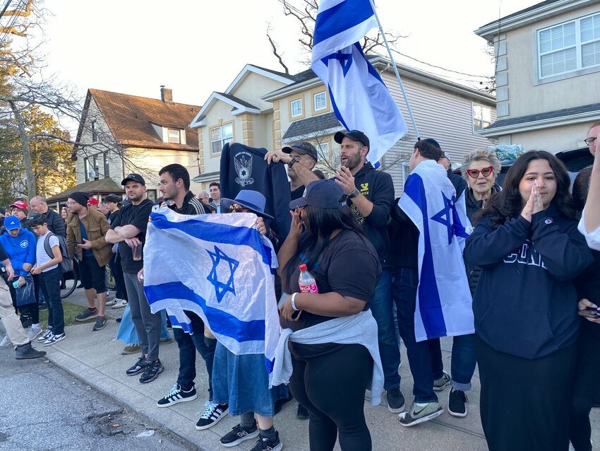Jewish protesters line the south side of Spruce Street in Cedarhurst as a group on the north side protests an Israeli real estate event, taking place at Young Israel of Lawrence-Cedarhurst on March 12.