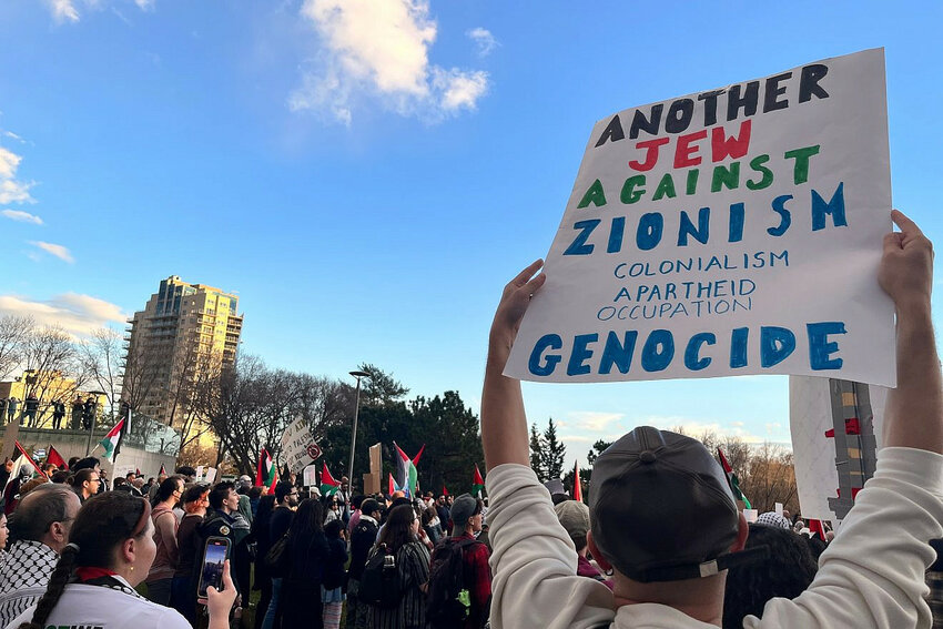 A person holds a sign reading &ldquo;Another Jew Against Zionism, Colonialism, Apartheid, Occupation, Genocide&rdquo; at a protest at the Alberta Legislature in Edmonton, Canada, on Oct. 18, 2023.