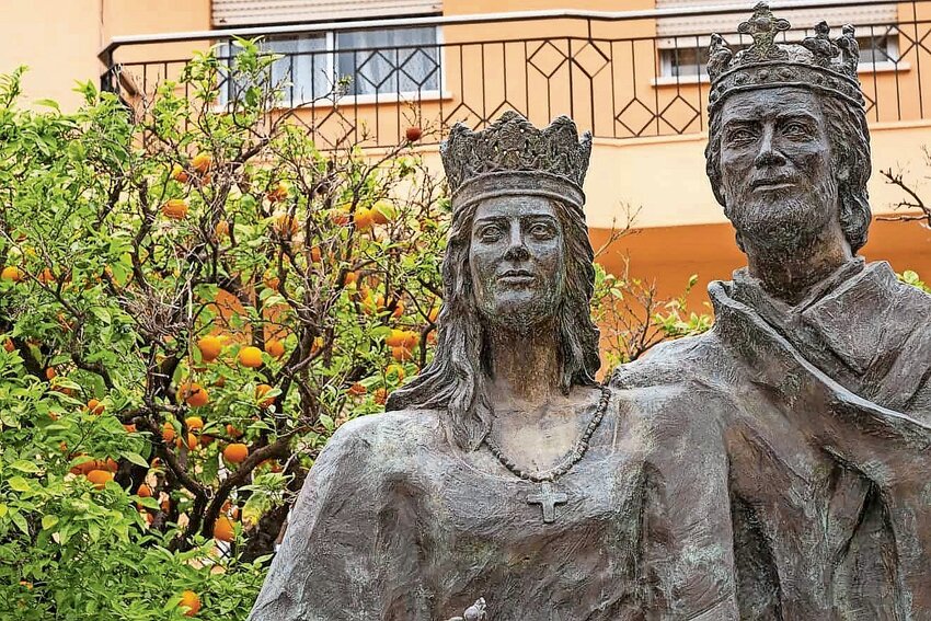 Bronze statues of Queen Isabella I of Castile and King Ferdinand II of Aragon, 15th-century rulers of Spain, among orange trees in the Plaza del Ayuntamiento at Fuengirola in southern Spain.