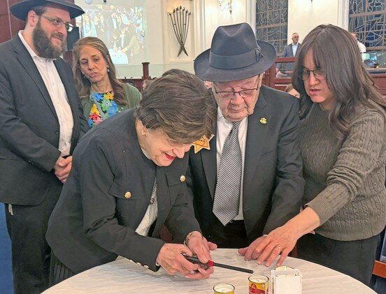Paul Gross, a child survivor from Hungary, accompanied by his wife and family members, lit a candle at the Greater Five Towns Community Yom Hashoah Commemoration last Wednesday.