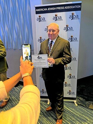 Jonathan Tobin displays a first-place Simon Rockower award he received from the American Jewish Press Association at its convention in Atlanta in 2022.