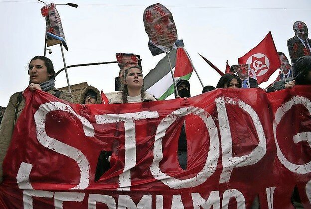 Anti-Israel protesters hold a red banner with the word &ldquo;Stop&rdquo; and effigies of Israeli Prime Minister Benjamin Netanyahu, Italian Prime Minister Giorgia Meloni and other leaders during a demonstration in Milan, Italy, on Feb. 24, 2024.
