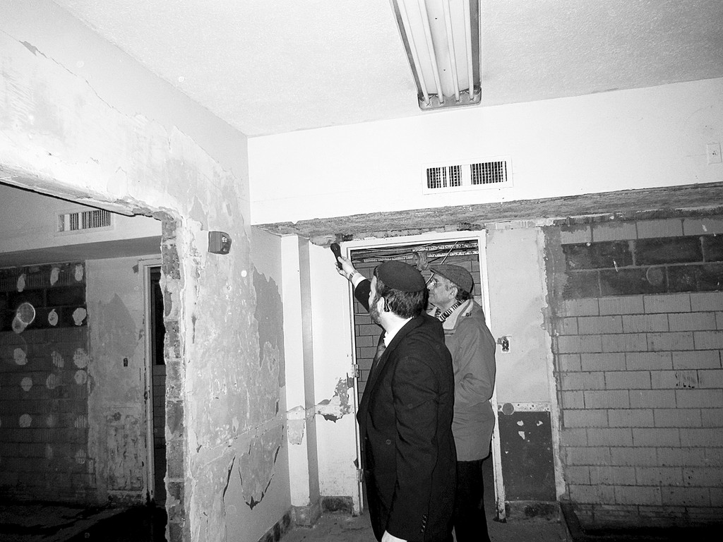 Rabbi Tsvi Selengut, left, showing the water level in the stripped down basement classrooms. Ohab Zedek member Rabbi Bennet Rackman looks on.