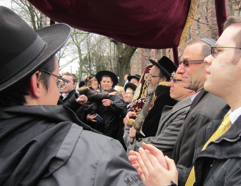 Men dance around the chuppah as Torahs are carried by Rabbis Mordechai Kamenetzky, Moshe Weinberger and Herschel Billet.