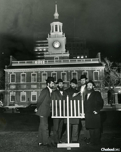 Chabad-Lubavitch says its first publlc menorah lighting took place in 1974 outside Independence Hall in Philadelphia, where Rabbi Abraham Shemtov, right, was joined yeshivah students who helped build the menorah from scratch.
