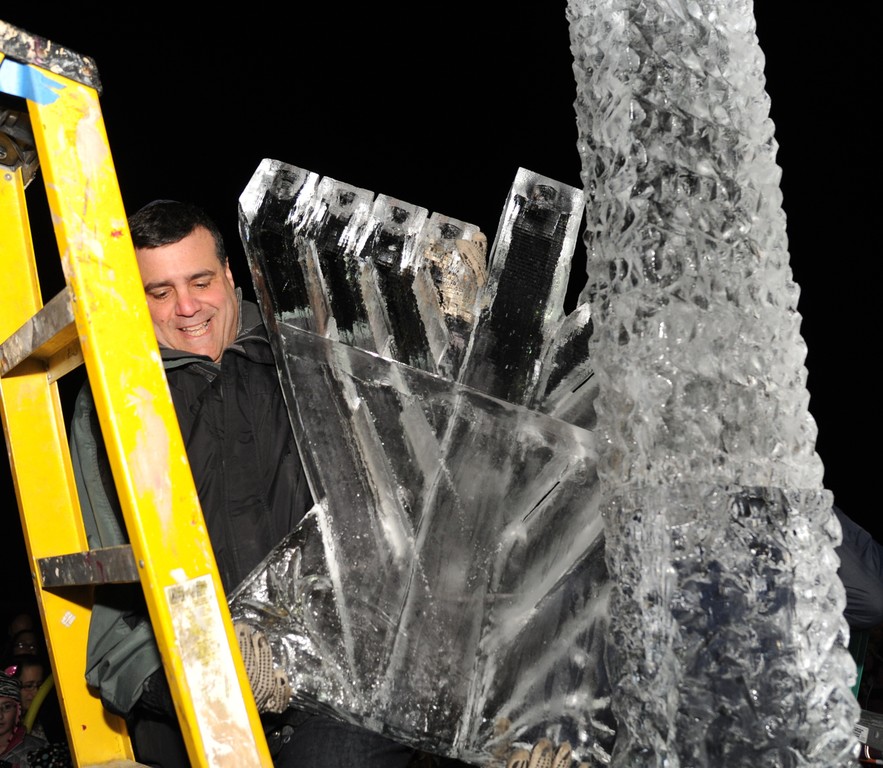 Curtis Izen of Merrick lifted a giant ice menorah atop a pedestal on Sunday.