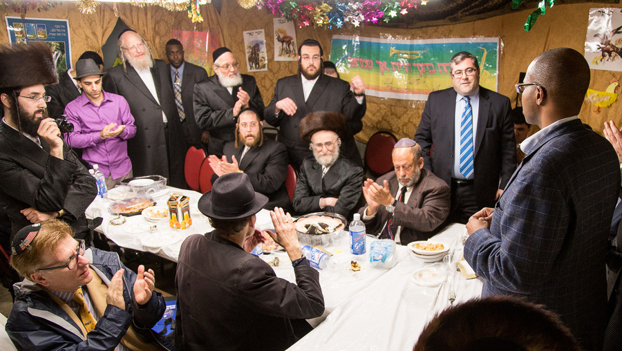 Ken Thompson (right) speaks in the Liska Sukkah in October 2014. He was hosted by Ezra Friedlander, CEO of The Friedlander Group (standing near right).