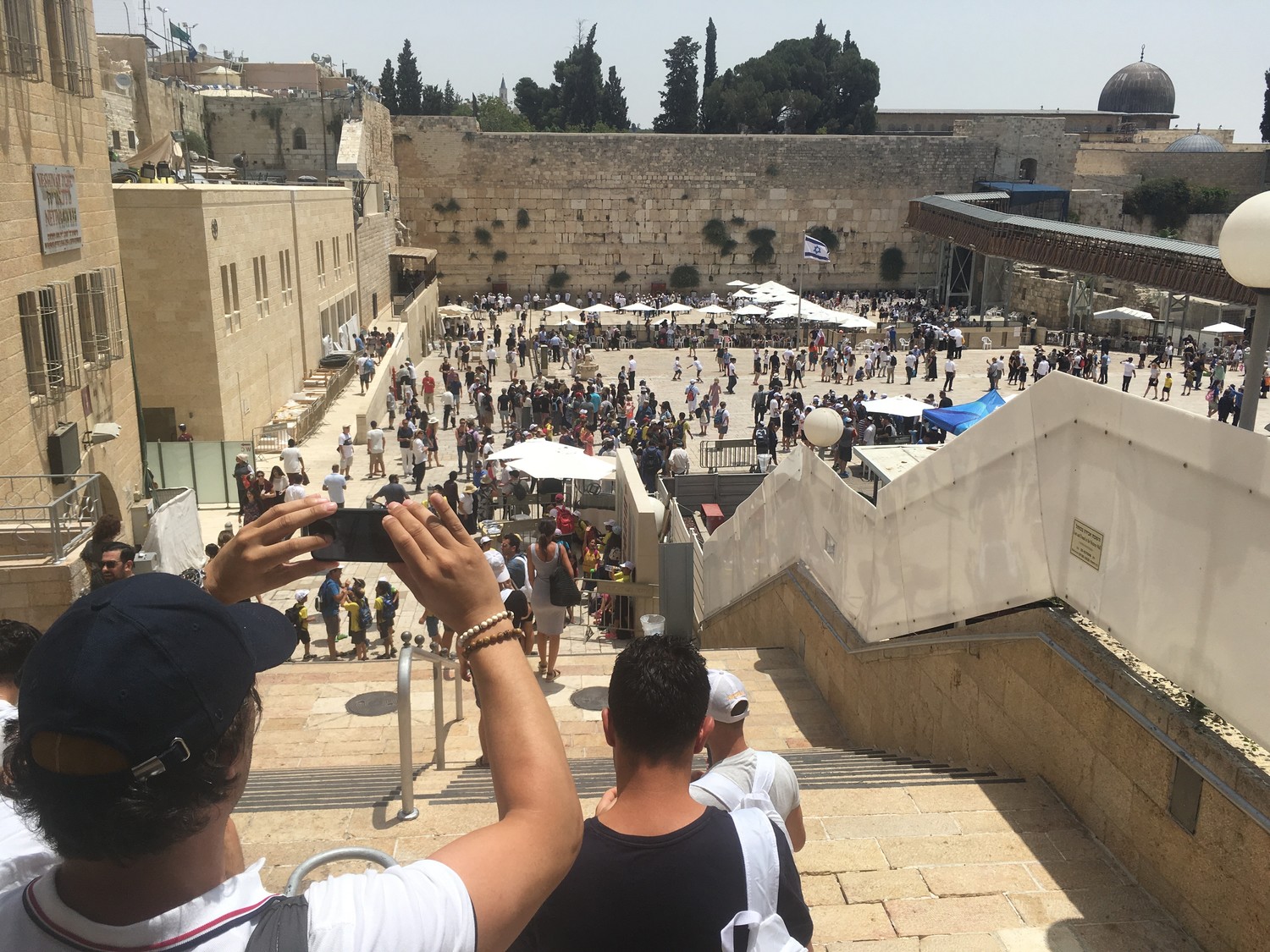 Tourists enter the Kotel plaza, as Jews pray at the holy site.