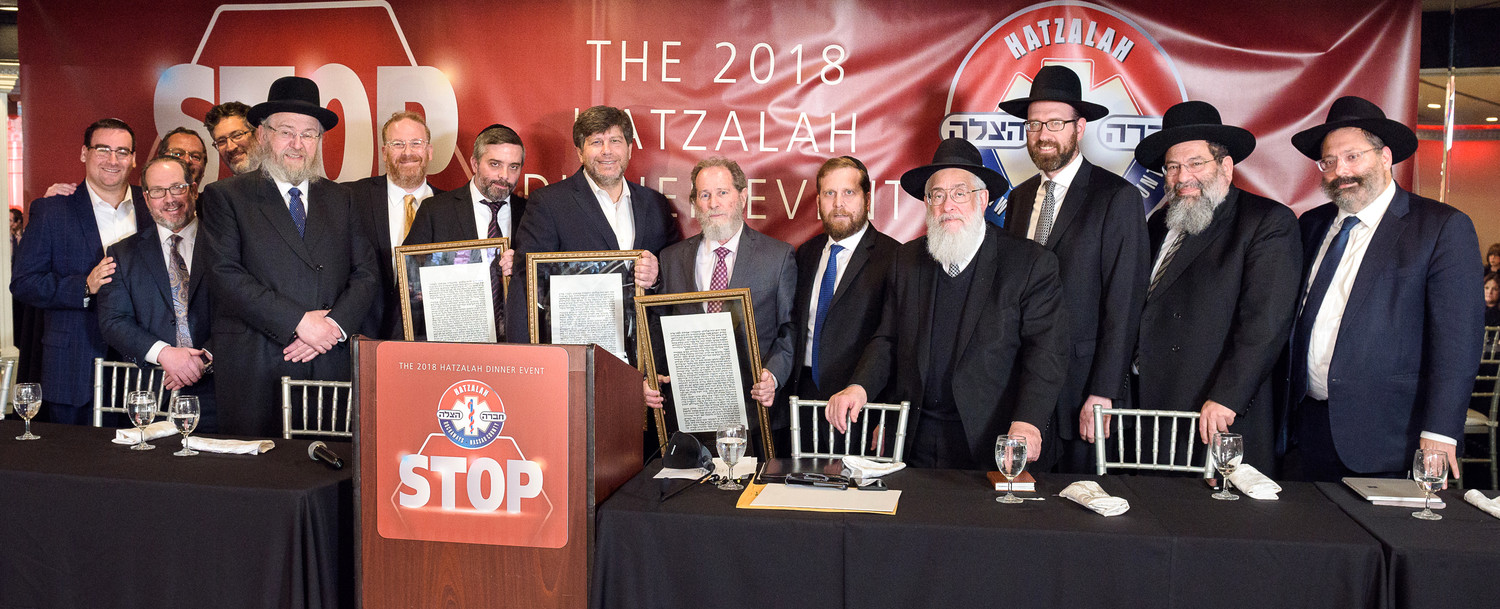 Hatzalah members, officials and honoreesincluding (holding their plaques) Yechiel Zlotnick, Shea Farkas and Mike Krengel.