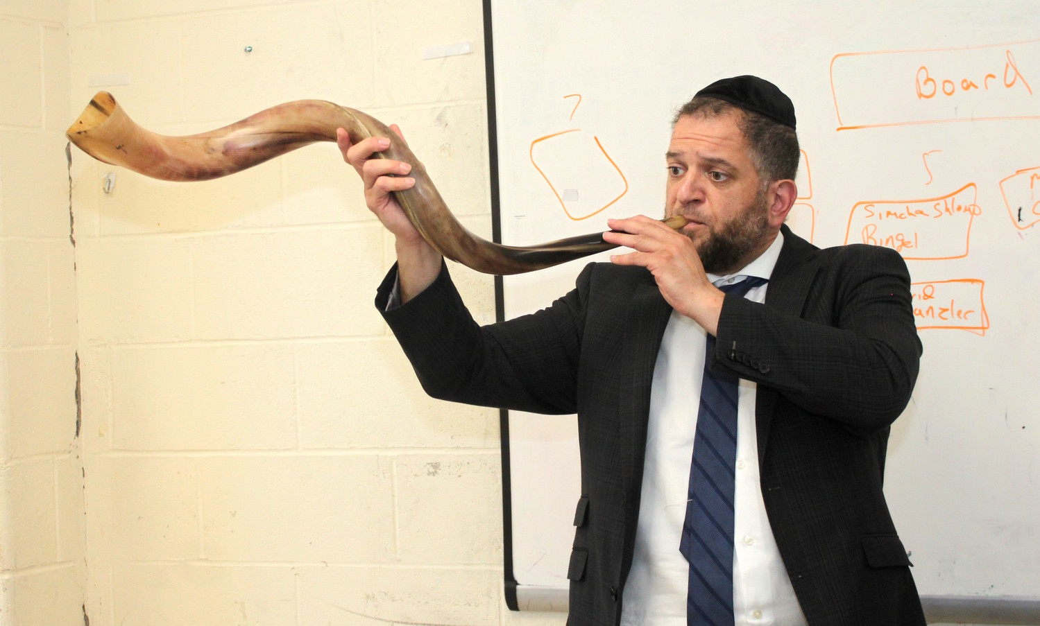 Rabbi Avrohom Moshe Heller, a second grade rebbi at Yeshiva Darchei Torah in Far Rockaway, blows the shofar of a kudu for his class on Tuesday, the first day of school.