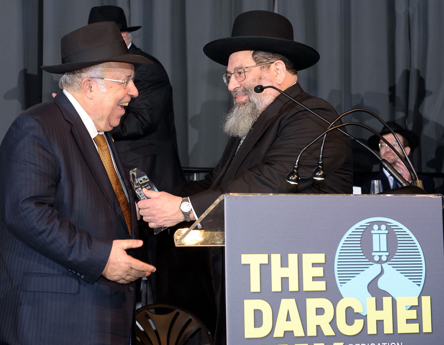 Rabbi Yaakov Bender makes a surprise presentation to Rabbi Lloyd Keilson, co-chairman of the YDT board, in recognition of his tireless efforts on the school's mortgage refinance.