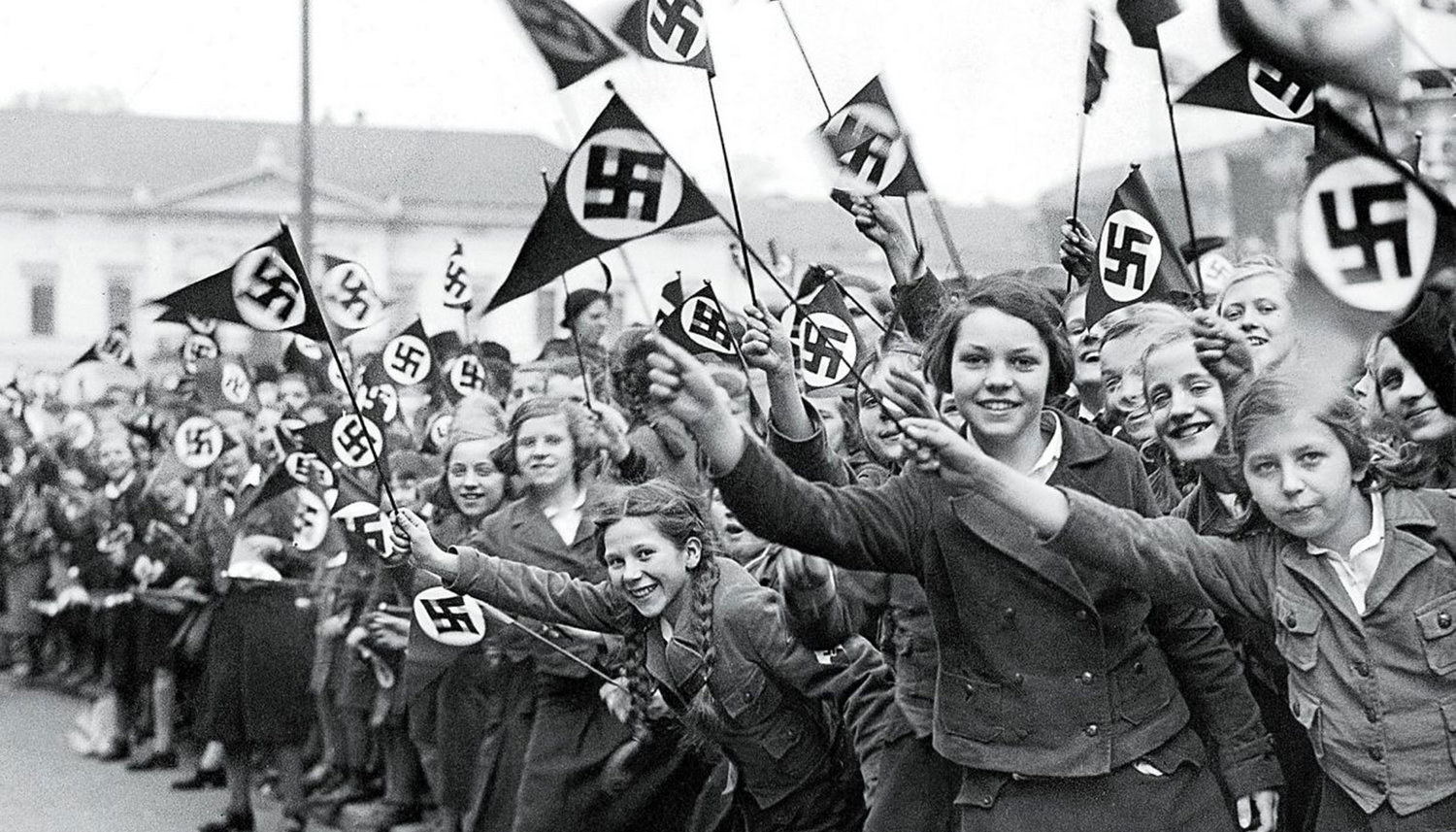 Members of the League of German Girls wave Nazi flags in support of the German annexation of Austria, in Vienna, March 1938.