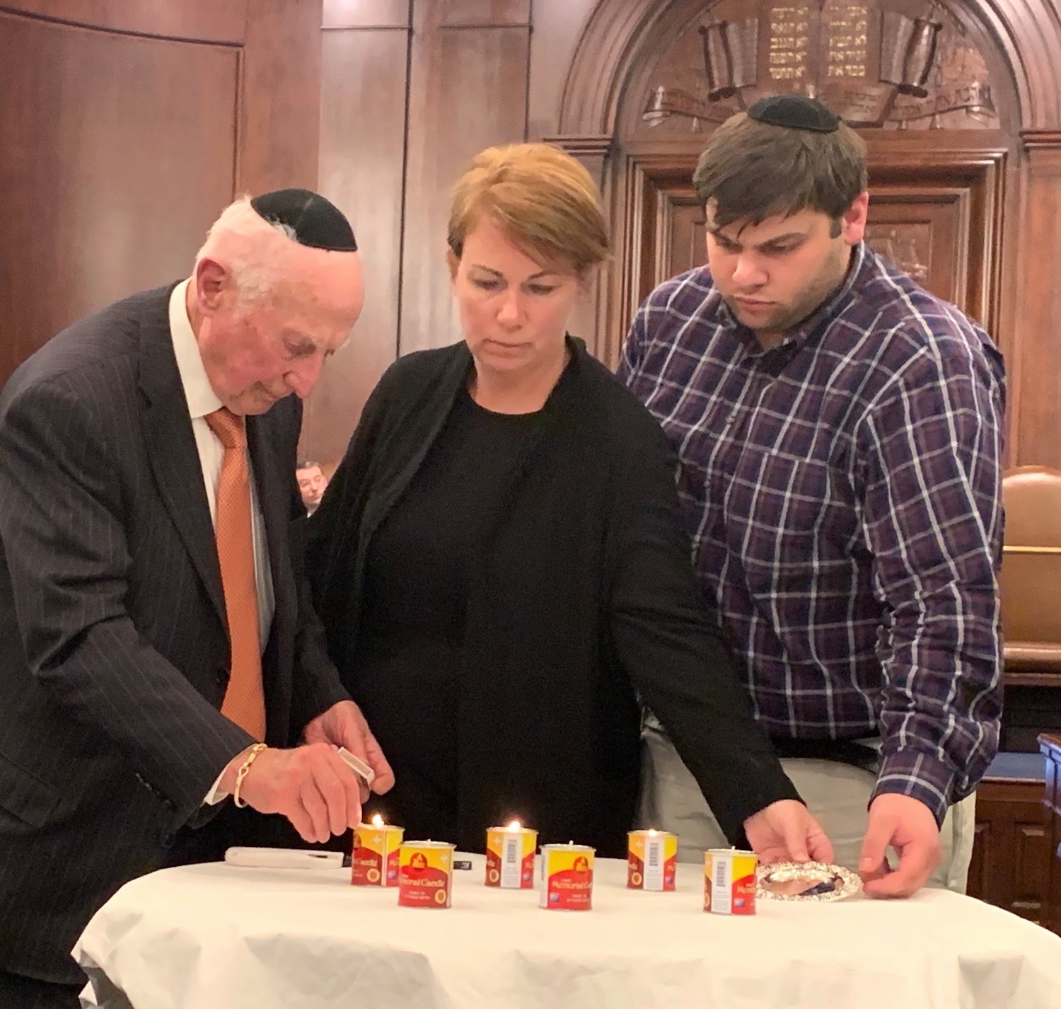 Survivor Frank Berger lights a memorial candle at Five Towns Holocaust remembrance event, at Congregation Beth Sholom in Lawrence, March 1, 2019.