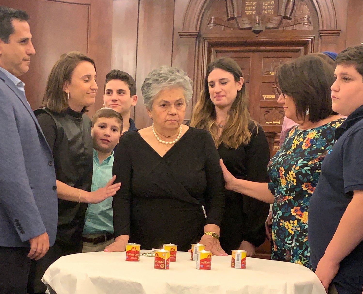 Survivor Luba Schulsinger lights a memorial candle at Five Towns Holocaust remembrance event, at Congregation Beth Sholom in Lawrence, March 1, 2019.