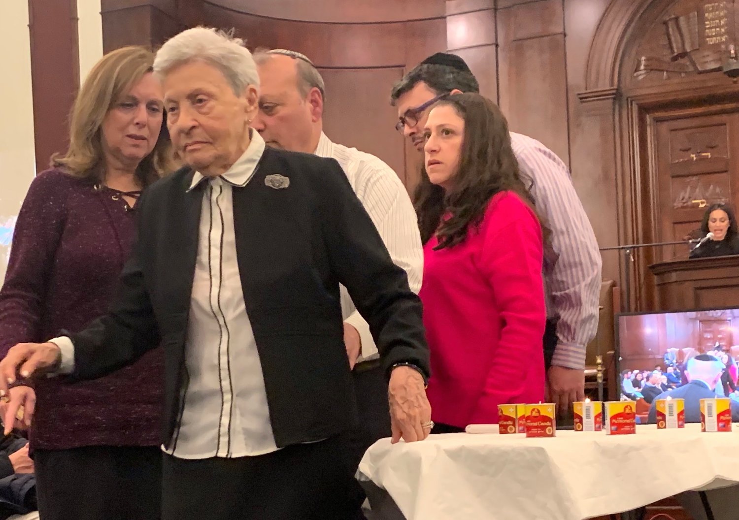 Survivor Natalie Gomberg lights a memorial candle at Five Towns Holocaust remembrance event, at Congregation Beth Sholom in Lawrence, March 1, 2019.