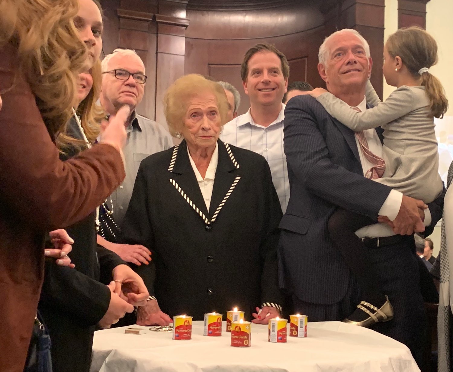 Survivor Phyllis Margulies lights a memorial candle at Five Towns Holocaust remembrance event, at Congregation Beth Sholom in Lawrence, March 1, 2019.