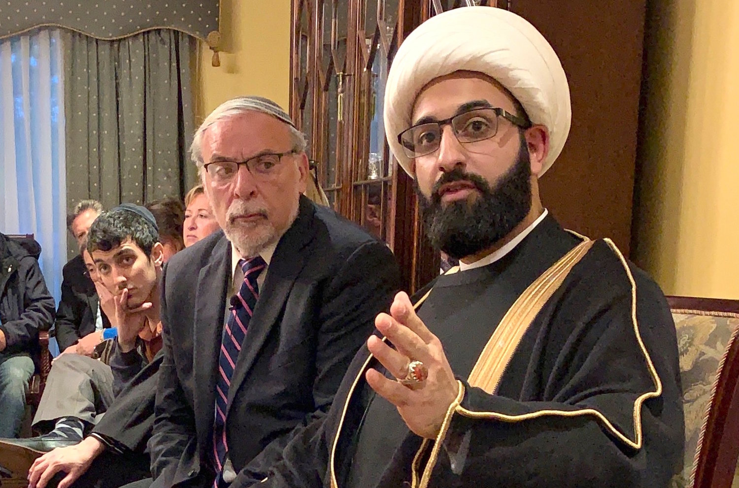 Imam Mohammad Tawhidi speaks, flanked by former Assemblyman Dov Hikind, at a parlor meeting in Woodmere.