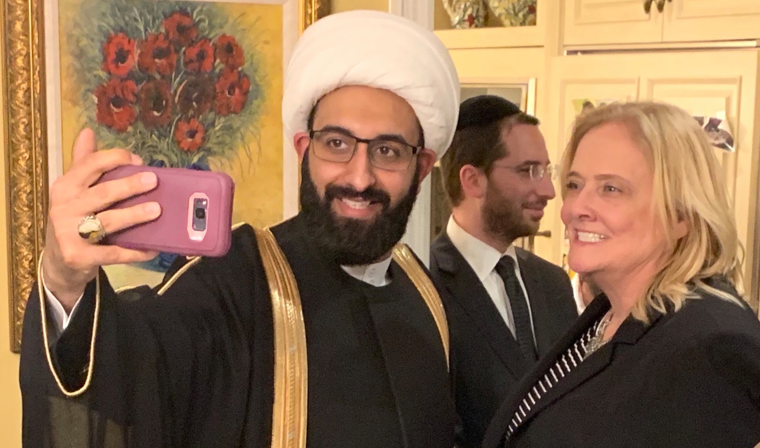 Imam Mohammad Tawhidi takes a selfie at the request of a fan, a Christian supporter of Israel who traveled to Woodmere to meet Tawhidi at last Wednesday evening’s parlor meeting.