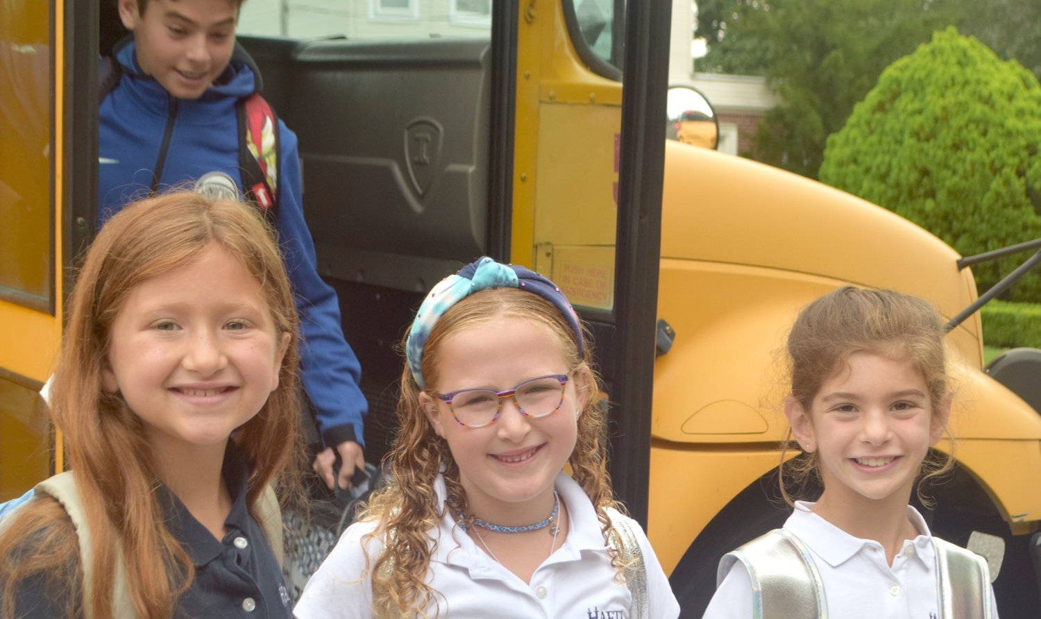 HAFTR third-graders Michelle Hersh, 8, Juliet Weinrib, 7 and Grace Rosenberg, 8, are all smiles as they left their bus on the first day of school.