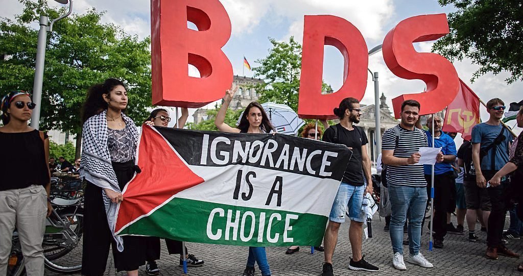 Protesters in Berlin hold a Palestinian flag and the initials of the anti-Israel BDS movement as Israeli Prime Minister Benjamin Netanyahu was visiting Germany in August 2019.