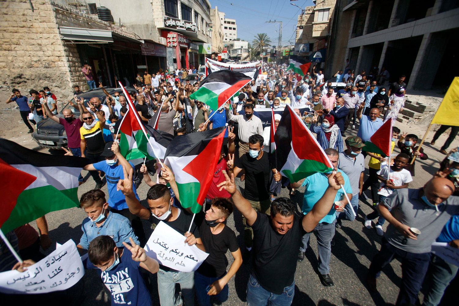 Palestinians hold flags during a rally in support of Palestinian President Mahmoud Abbas in the West Bank town of Tubas on Sept. 27.