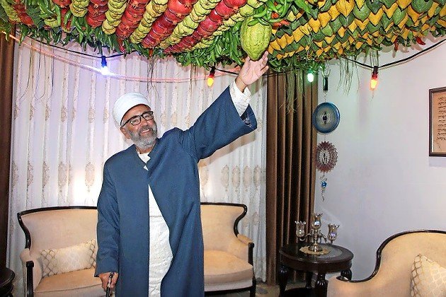 Samaritan priest Husney Wasef Cohen welcomes visitors into his indoor sukkah.