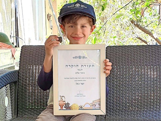Imri Elya with an ancient tablet and a certificate of recognition from the Israel Antiquities Authority.