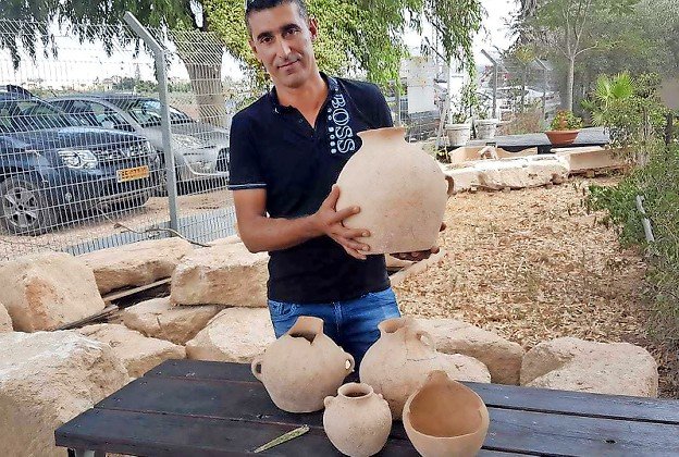 Electrician Ahmed Nassar Yassin with the ancient treasures he found.