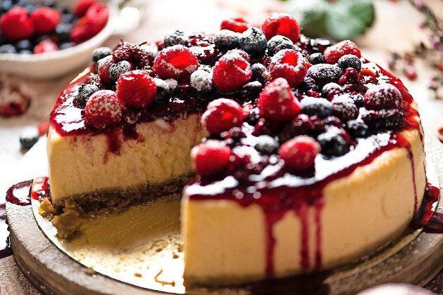 Mixed berries cheesecake with a slice cut out