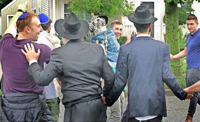 Rabbi Goodman connects with Alec Kremins, dancing on Walnut Street in celebration of Long Beach’s new Torah.